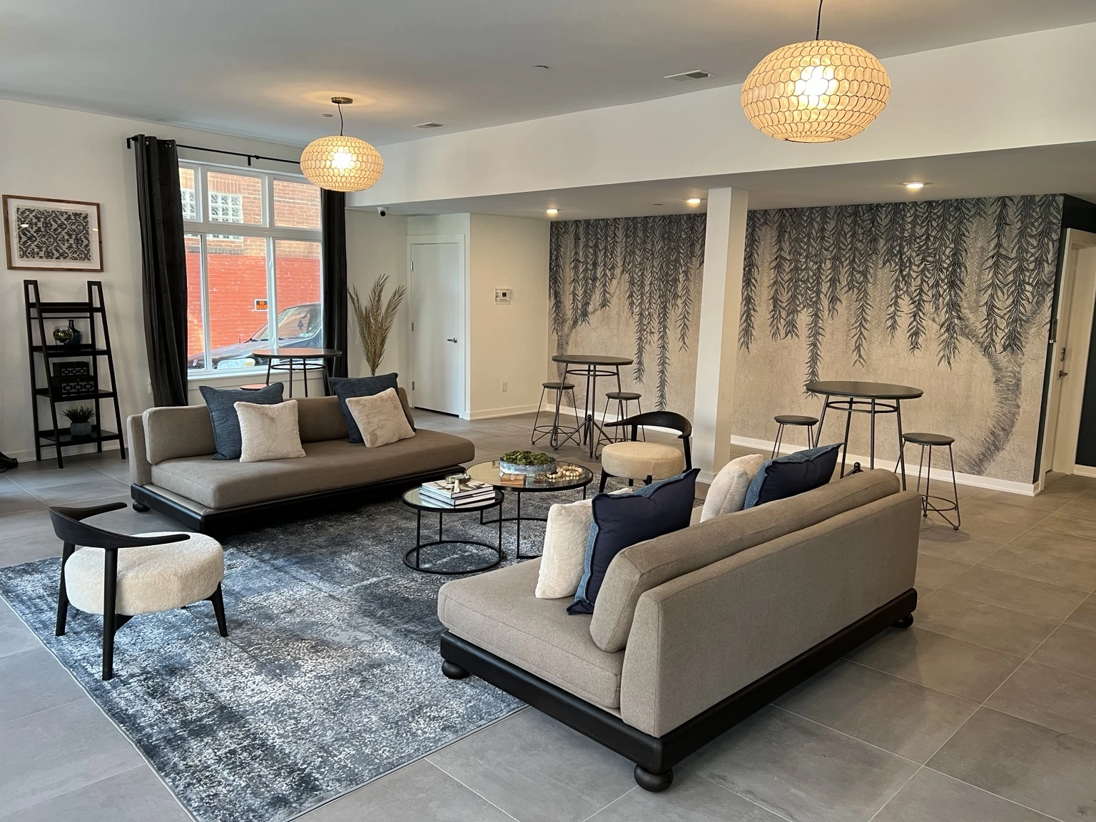 A bright living space shared by Gary, with pendant lighting, large windows and thoughtfully arranged furnishings