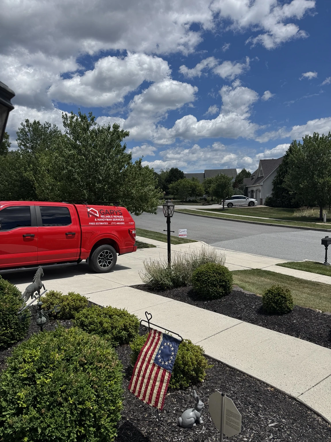 Gary’s branded truck on a neighborhood street near a landscaped front walk
